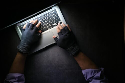 gloved hands on computer keyboard